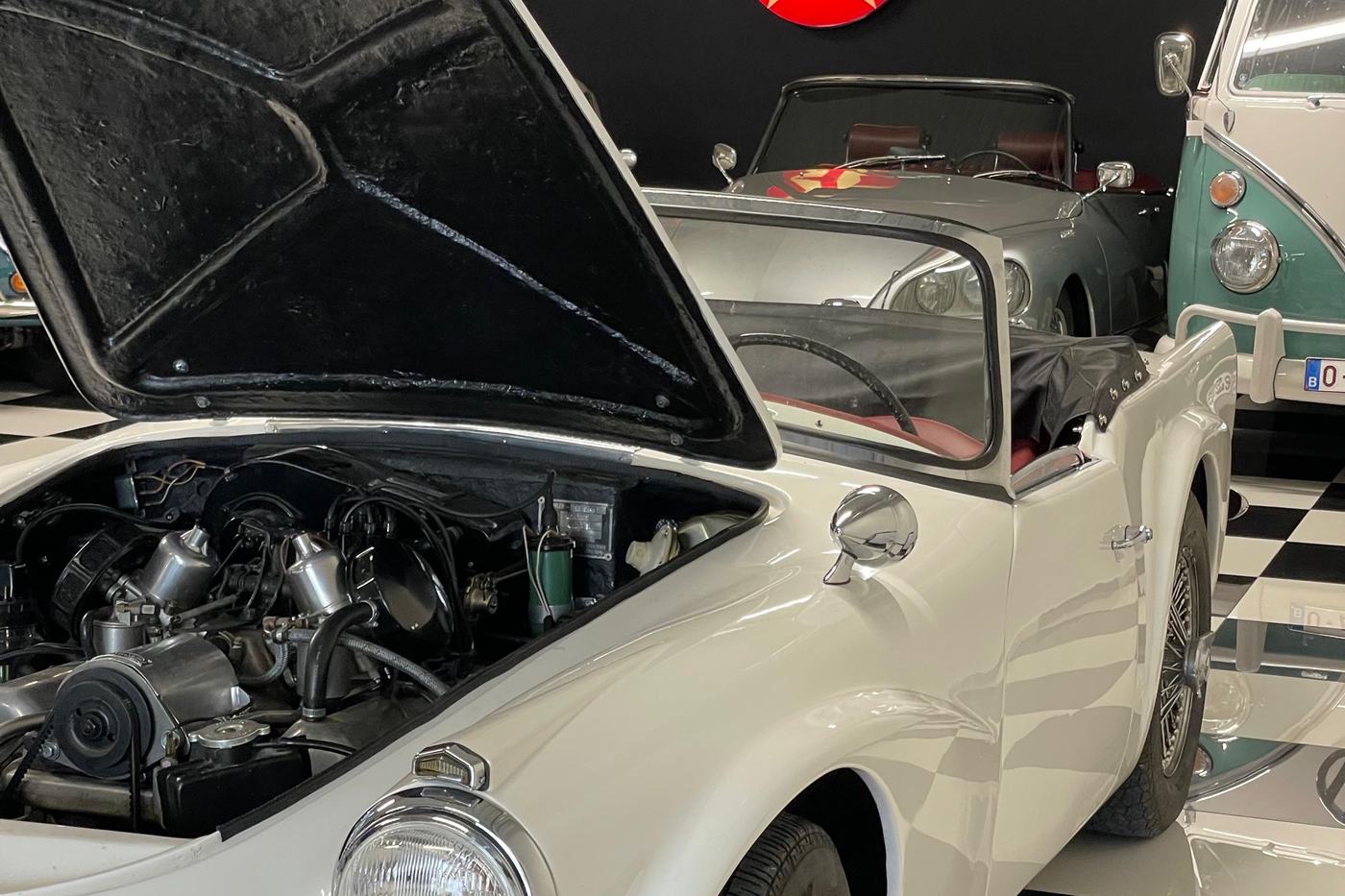 Daimler SP250 « Dart » blanche, capot ouvert sur son moteur V8, dans le garage DeVinCi
