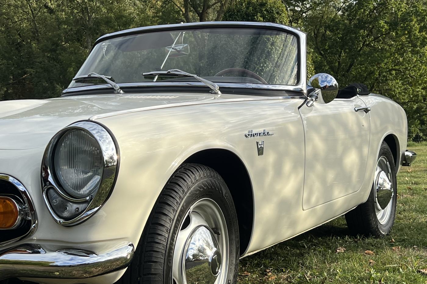 Honda S800 blanc de 1968 vue de trois quarts avant, phare rond et jantes chromées